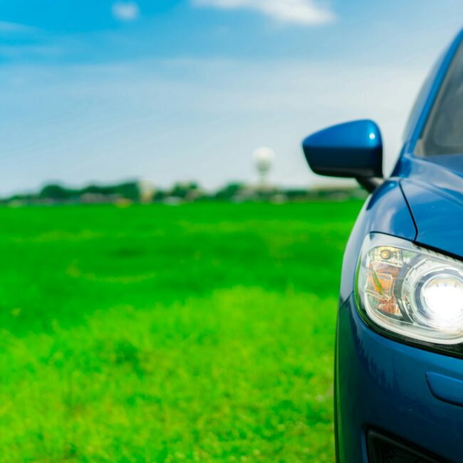 Front view of luxury blue compact SUV car with sport and modern design parked on green grass field